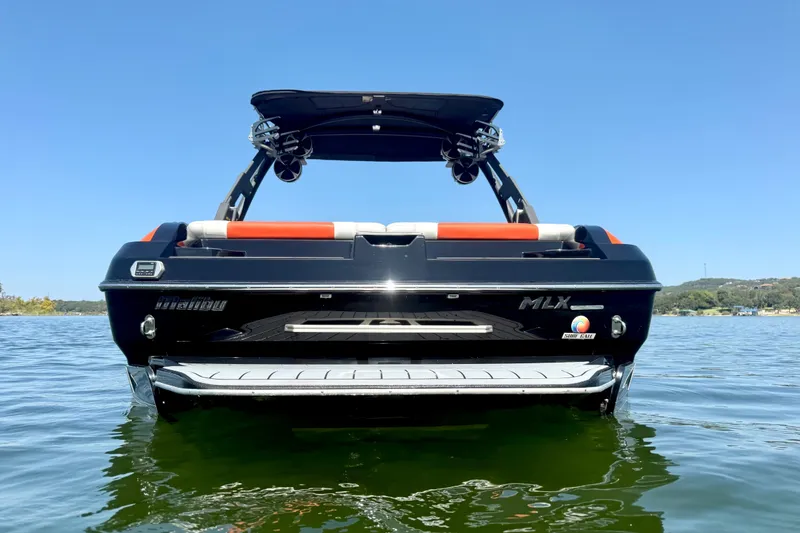 Slide: The Image of 2018 Malibu Wakesetter 21 MLX boat on calm water, rear view. - 5
