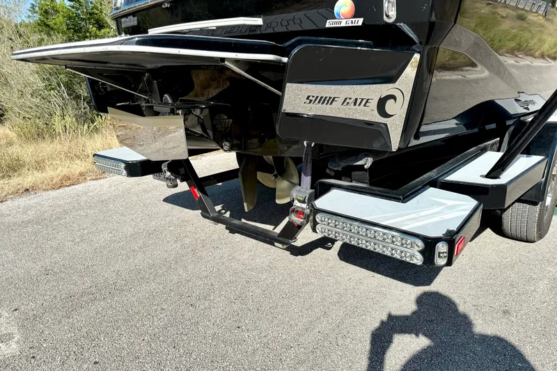 Slide: The Image of 2018 Malibu Wakesetter 21 MLX rear view with Surf Gate technology on a sunny day. - 17