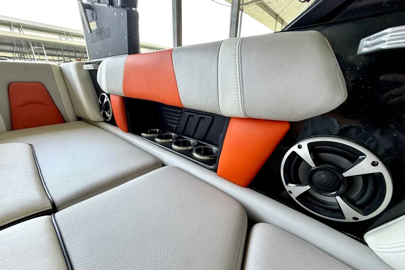 Slide: The Image of 2018 Malibu Wakesetter 21 MLX interior with orange accents, speakers, and cup holders. - 32
