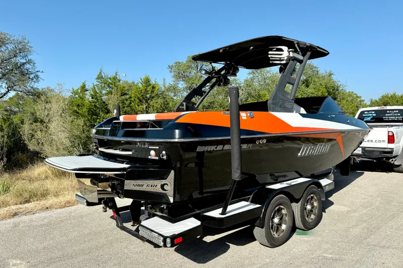 Slide: The Image of 2018 Malibu Wakesetter 21 MLX boat on trailer, parked outdoors. - 16