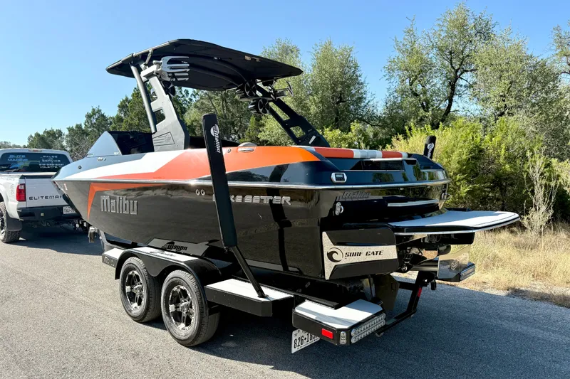 Slide: The Image of 2018 Malibu Wakesetter 21 MLX boat on trailer, parked on roadside. - 11