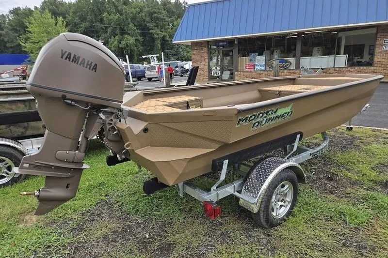 Slide: The Image of 2027 Havoc 1656 MRST MACH 1 boat with Yamaha motor on trailer, parked outside a store. - 2