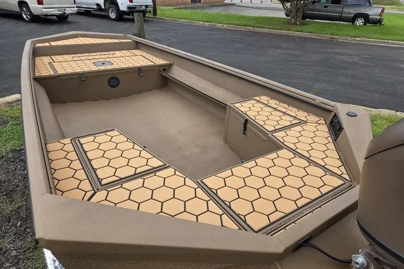 Slide: The Image of 2027 Havoc 1656 MRST MACH 1 boat with hexagonal deck pattern, parked outdoors. - 7