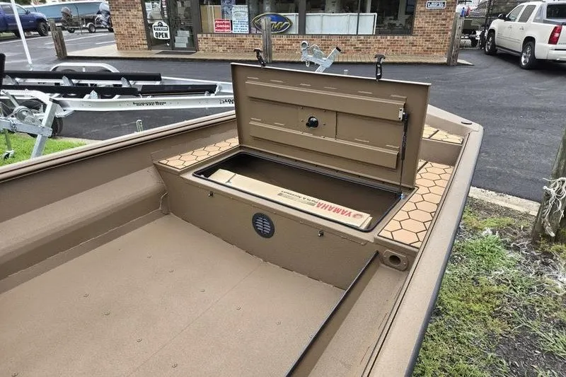 Slide: The Image of 2027 Havoc 1656 MRST MACH 1 boat with open storage compartment, parked outside a store. - 9
