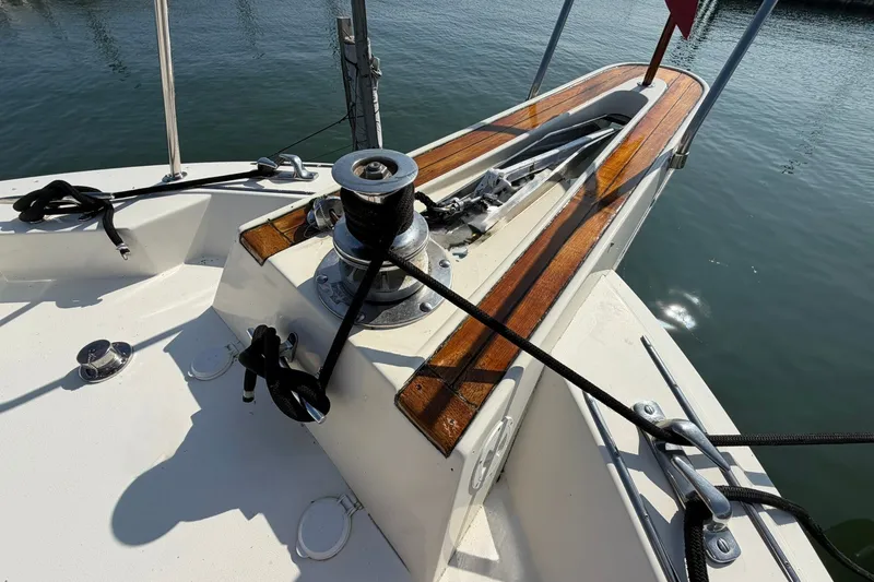 Slide: The Image of 1986 Hatteras 63 Cockpit Motor Yacht deck with winch and wooden accents. - 69