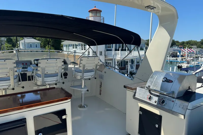 Slide: The Image of 1986 Hatteras 63 Cockpit Motor Yacht with outdoor seating and grill on deck. - 59