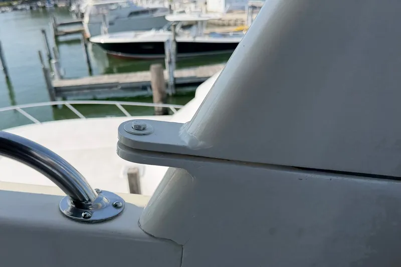 Slide: The Image of Close-up of 1986 Hatteras 63 Cockpit Motor Yacht railing and docked boats in background. - 67
