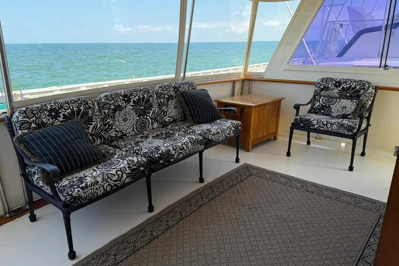 Slide: The Image of Interior of 1986 Hatteras 63 Cockpit Motor Yacht with floral seating and ocean view. - 23