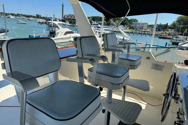 Slide: The Image of Cockpit view of 1986 Hatteras 63 Cockpit Motor Yacht with marina backdrop. - 62