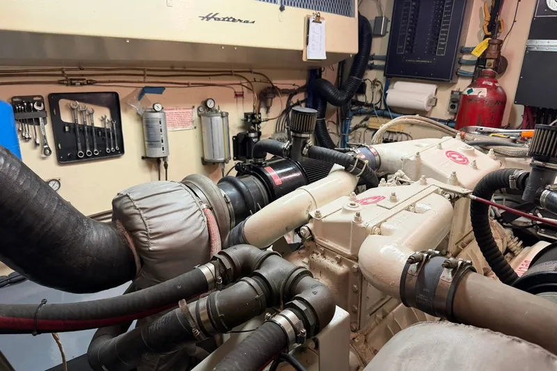 Slide: The Image of Engine room of 1986 Hatteras 63 Cockpit Motor Yacht with visible tools and machinery. - 77