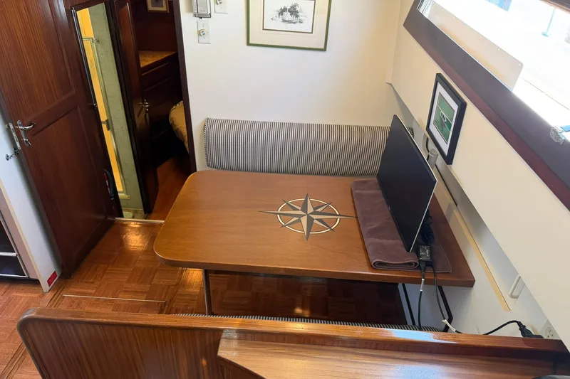 Slide: The Image of Interior of 1986 Hatteras 63 Cockpit Motor Yacht with table and seating area. - 28