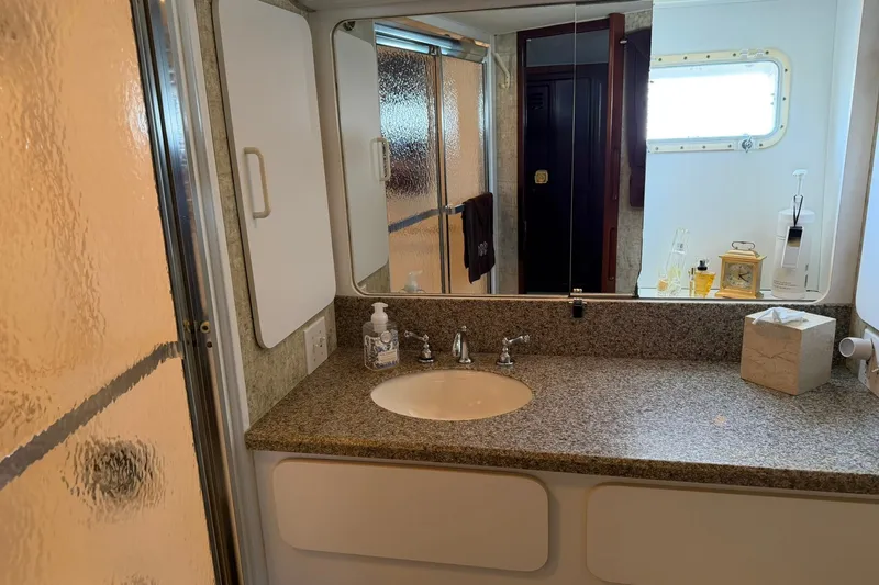 Slide: The Image of Luxurious bathroom in 1986 Hatteras 63 Cockpit Motor Yacht with granite countertop and mirror. - 51