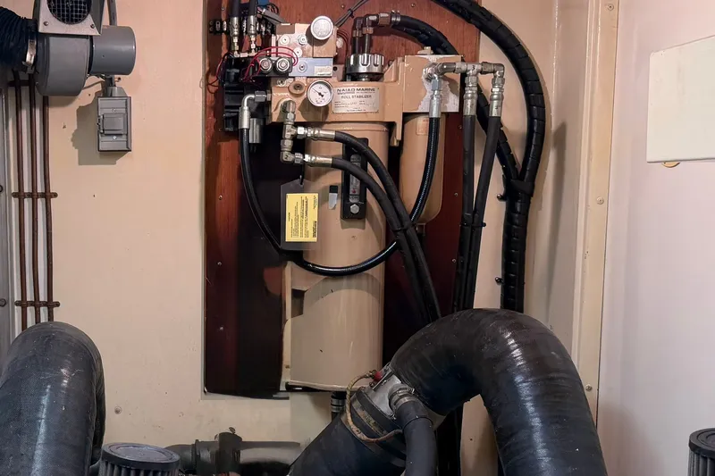 Slide: The Image of Engine room of 1986 Hatteras 63 Cockpit Motor Yacht with hydraulic system components. - 80