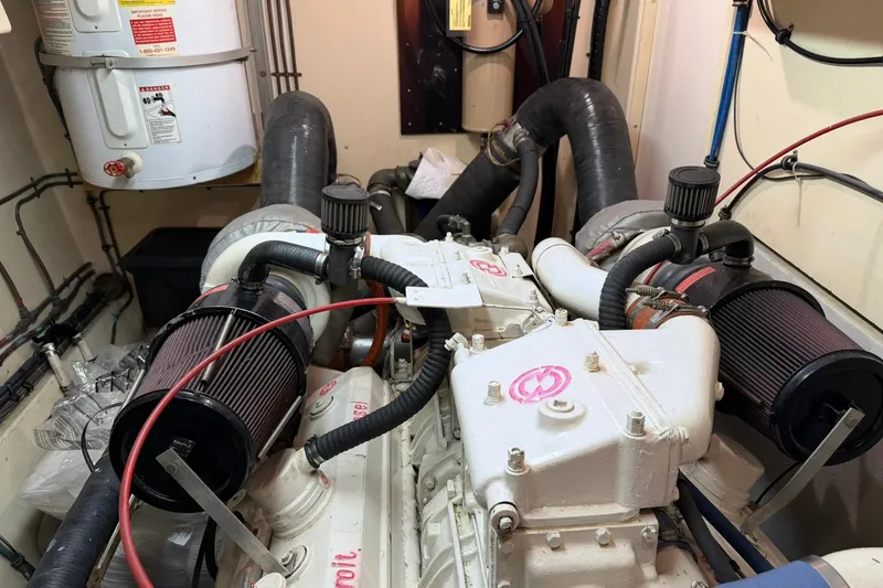 Slide: The Image of Engine room of a 1986 Hatteras 63 Cockpit Motor Yacht, showcasing dual engines and components. - 81