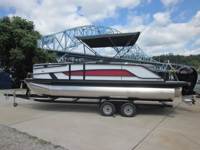 Slide: The Image of A 2027 Evotti 521 QL pontoon boat on a trailer, set against a bridge backdrop. - 2