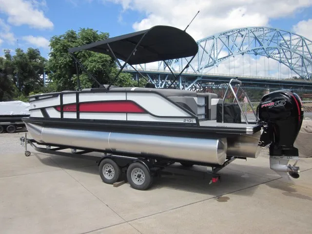 Slide: The Image of A modern pontoon boat with a black canopy and red accent, on a trailer near a bridge. - 4
