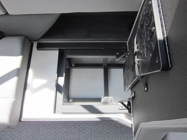 Slide: The Image of An open storage compartment in the floor of a boat, surrounded by gray upholstery. - 21