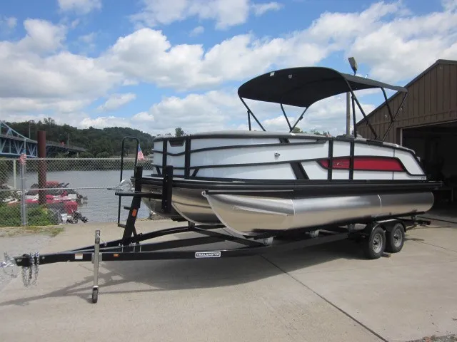 Slide: The Image of A 2027 Evotti 521 QL pontoon boat on a trailer beside a river. - 3
