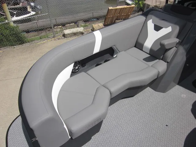Slide: The Image of Gray upholstered seating with white accents on a boat, surrounded by a fence and concrete ground. - 12