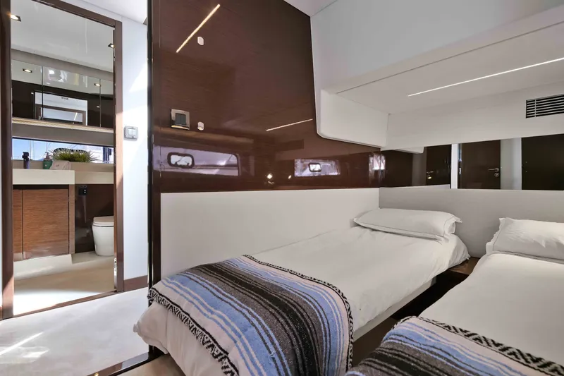 Slide: The Image of Luxurious twin cabin interior on a 2022 Prestige 590 yacht, featuring modern design and ensuite bathroom. - 61