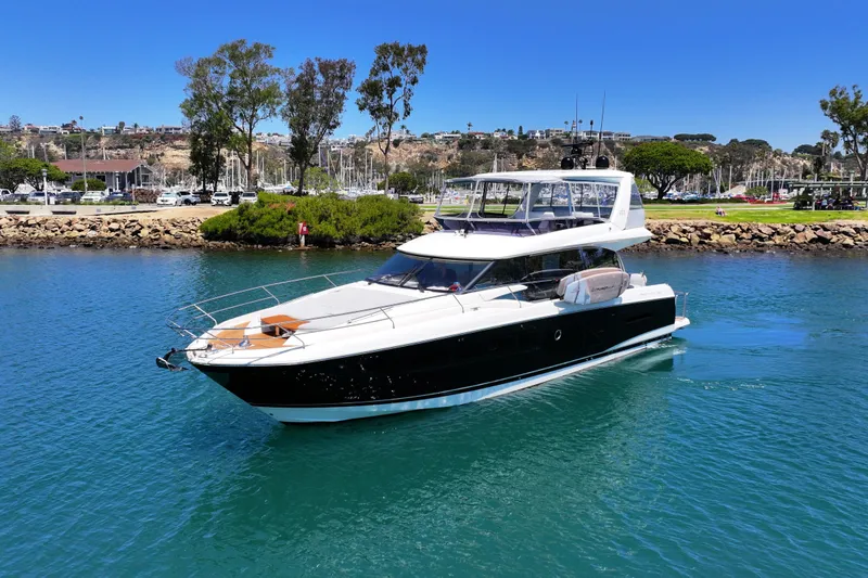 Slide: The Image of Luxury 2022 Prestige 590 yacht cruising in a scenic marina setting. - 6