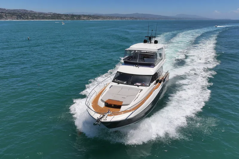 Slide: The Image of Luxury 2022 Prestige 590 yacht cruising on open sea, leaving a wake behind. - 14