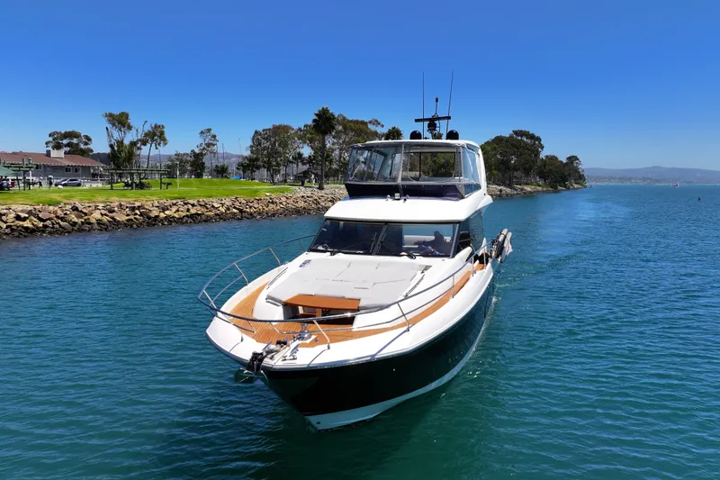 Slide: The Image of Luxury 2022 Prestige 590 yacht cruising in a scenic coastal waterway. - 5