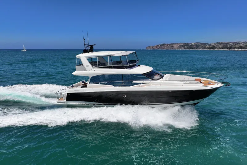 Slide: The Image of Luxury 2022 Prestige 590 yacht cruising on open sea with scenic coastline. - 8