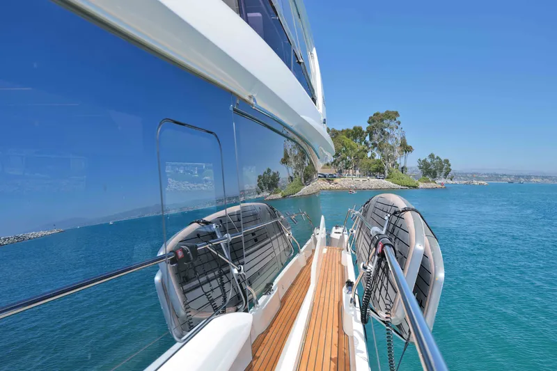 Slide: The Image of Prestige 590 yacht, 2022 model, cruising near a scenic coastline with clear blue waters. - 17