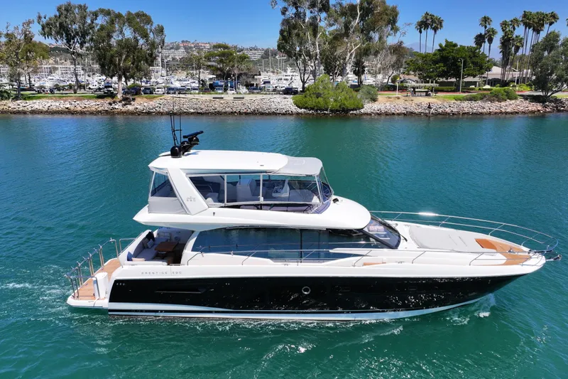 Slide: The Image of Luxury 2022 Prestige 590 yacht cruising in a scenic marina setting. - 1