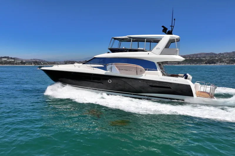 Slide: The Image of Luxury 2022 Prestige 590 yacht cruising on clear blue waters. - 9