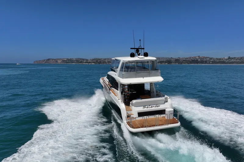 Slide: The Image of Luxury 2022 Prestige 590 yacht cruising on open sea near coastline. - 12