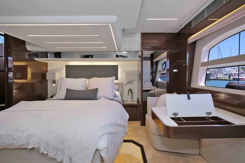 Slide: The Image of Luxurious interior of a 2022 Prestige 590 yacht, featuring a spacious bedroom with elegant furnishings. - 51