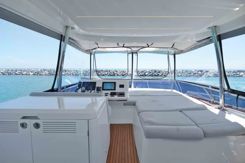 Slide: The Image of Luxurious 2022 Prestige 590 yacht interior with helm and sunbathing area, overlooking serene ocean. - 20