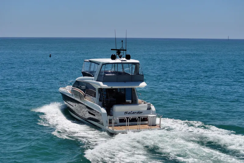 Slide: The Image of Luxury 2022 Prestige 590 yacht cruising on open sea under clear blue sky. - 11