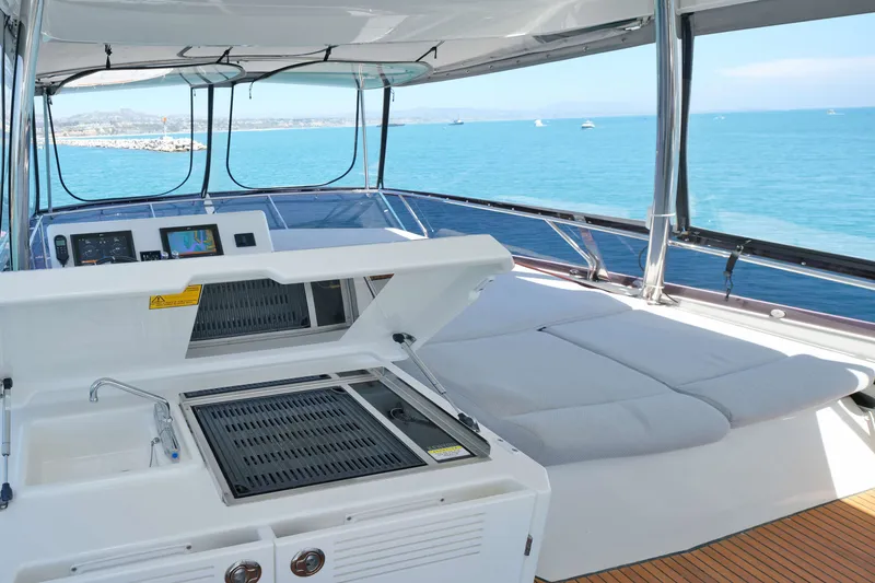Slide: The Image of Luxurious 2022 Prestige 590 yacht interior with grill and sunbathing area, overlooking the ocean. - 21
