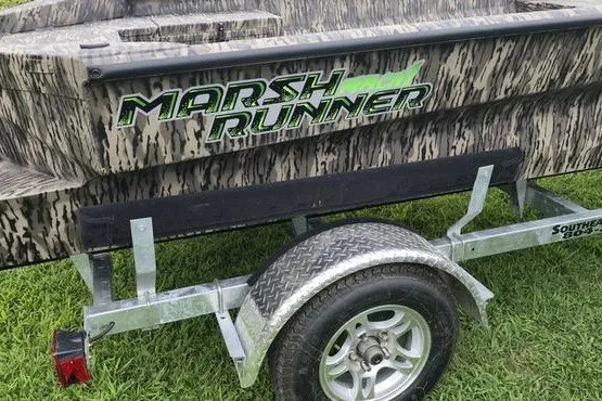 Slide: The Image of Trailer with 2027 Havoc 1656 MRST MACH 1 Marsh Runner boat on grass. - 12