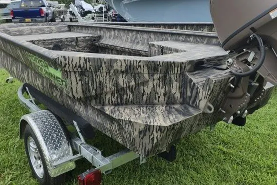 Slide: The Image of Camouflage-patterned 2027 Havoc 1656 MRST MACH 1 boat on trailer, parked on grass. - 1