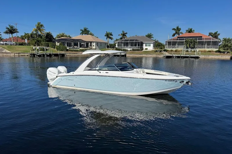 Slide: The Image of 2018 Cobalt 30SC boat on calm water, with waterfront homes and palm trees in the background. - 1