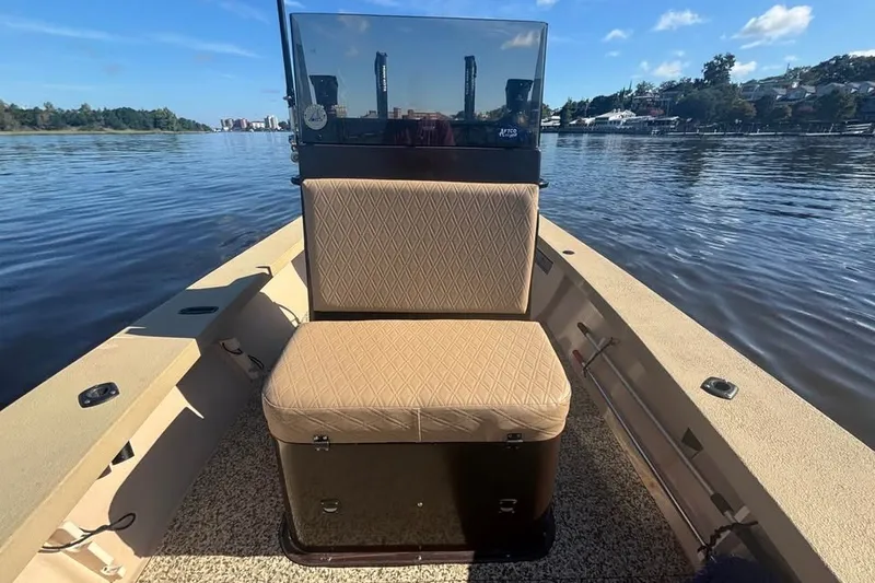 Slide: The Image of 2024 Jones Brothers Bateau 20 boat interior with cushioned seating on a calm lake. - 3