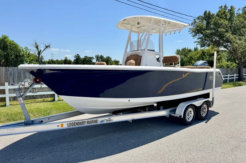 The Image of 2017 Sea Hunt Ultra 225 boat on trailer, parked on a sunny street. - 1