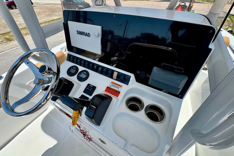 Slide: The Image of Console of a 2017 Sea Hunt Ultra 225 boat with steering wheel and controls. - 17