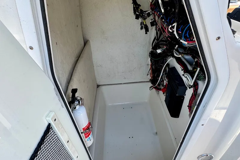 Slide: The Image of Interior view of a 2017 Sea Hunt Ultra 225 boat's wiring compartment with fire extinguisher. - 13