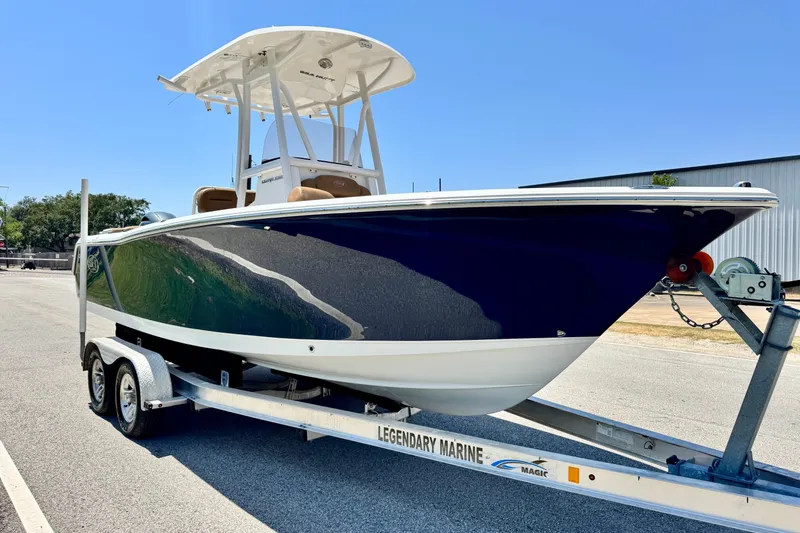 Slide: The Image of 2017 Sea Hunt Ultra 225 boat on trailer, parked outdoors under clear blue sky. - 5