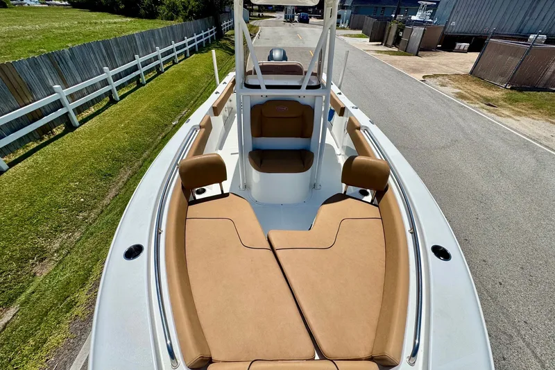 Slide: The Image of 2017 Sea Hunt Ultra 225 boat with tan seating and white deck, parked on a road. - 16