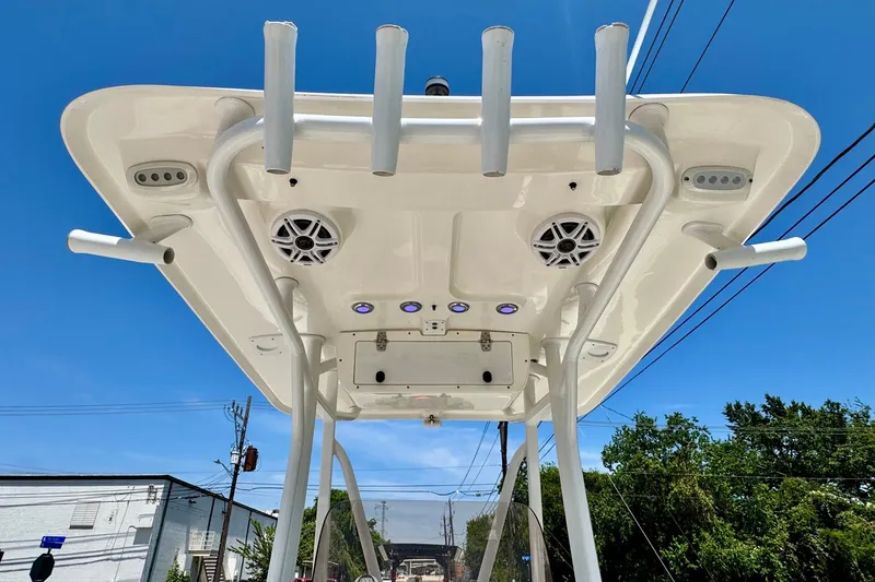 Slide: The Image of 2017 Sea Hunt Ultra 225 boat T-top with speakers and rod holders against blue sky. - 11