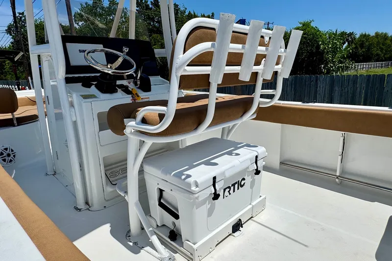 Slide: The Image of 2017 Sea Hunt Ultra 225 boat interior with helm, seating, and RTIC cooler. - 8
