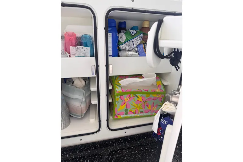 Slide: The Image of Storage compartments on a 2023 Sea Fox 368 Commander, stocked with essentials and colorful tissue box. - 43