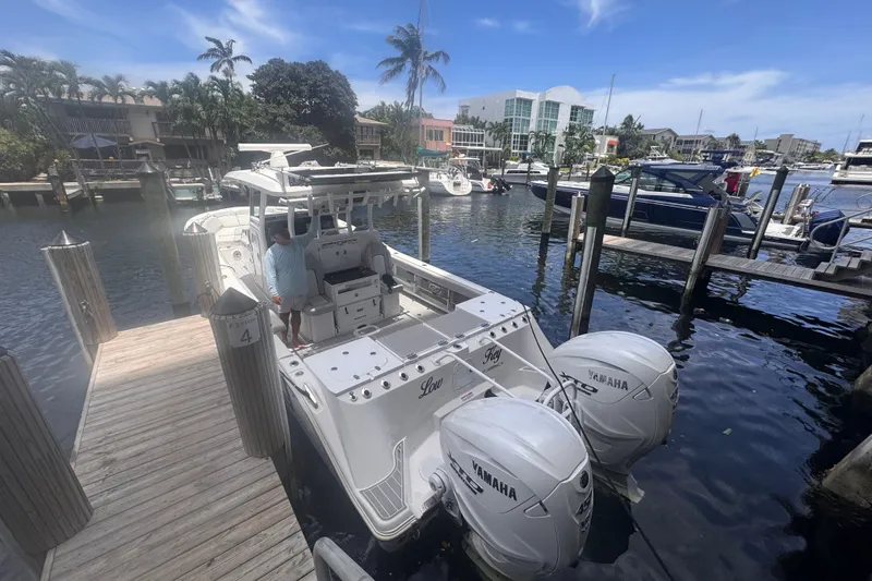 Slide: The Image of 2023 Sea Fox 368 Commander docked with twin Yamaha engines, surrounded by waterfront homes. - 60