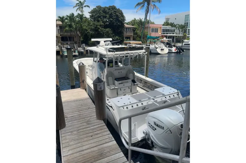 Slide: The Image of 2023 Sea Fox 368 Commander docked, featuring Yamaha engines, in a scenic marina setting. - 58